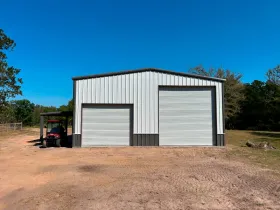A tractor is parked in front of a metal building.