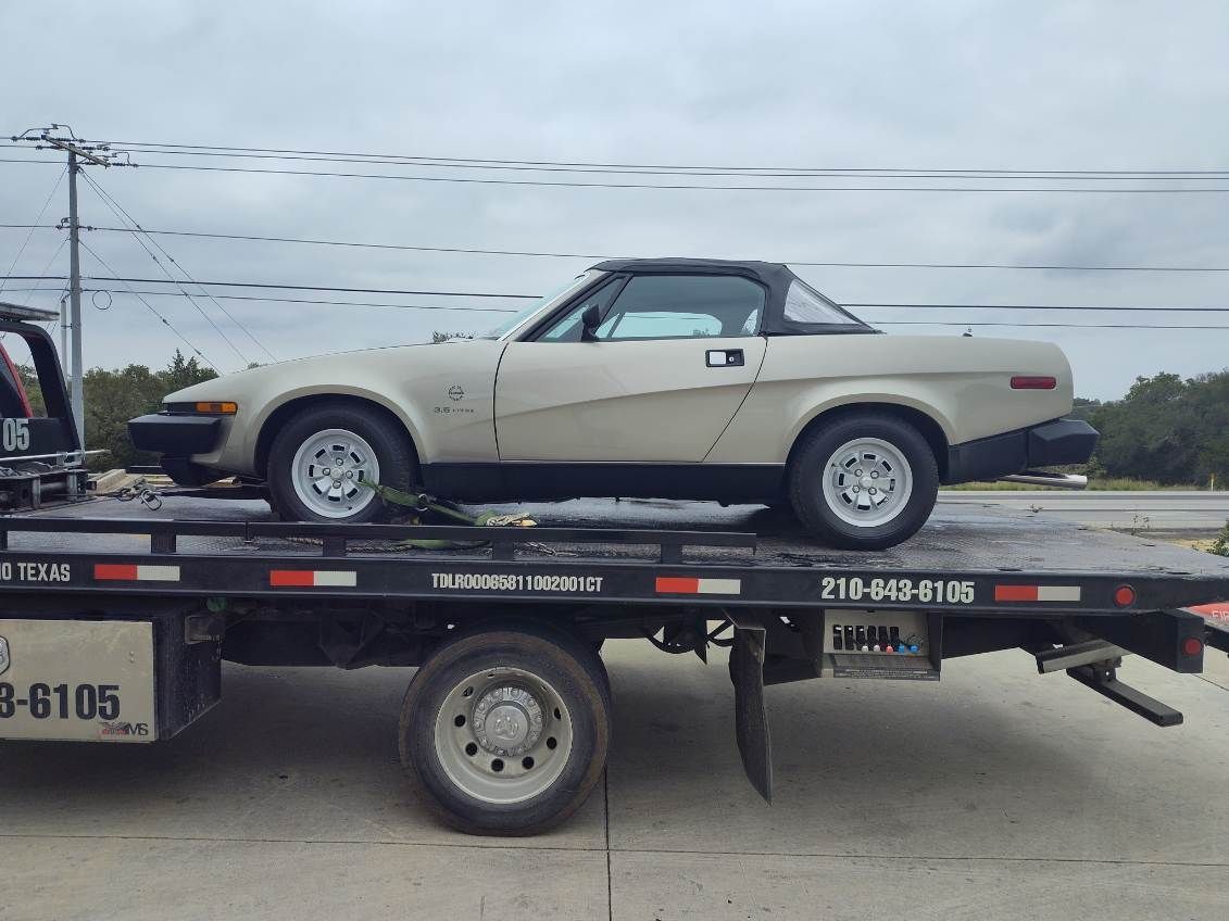 A white car is sitting on top of a tow truck.