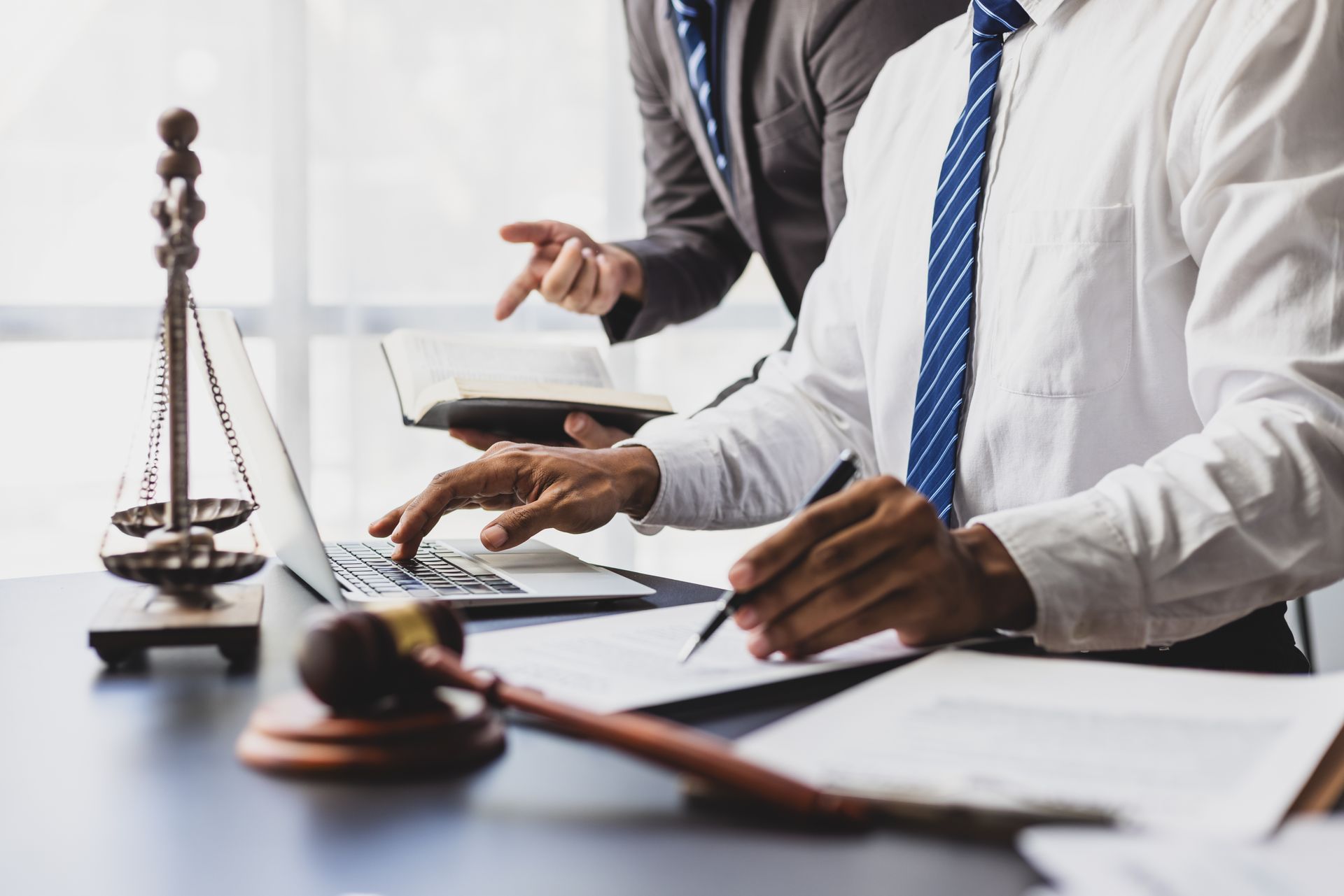 Two attorney reviewing documents at a desk Two attorney reviewing documents at a desk