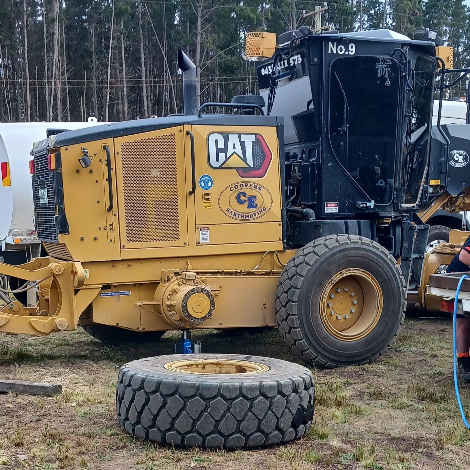 Yellow CAT Road Grader With a Detached Tyre in Front — BOEX Tyres And Performance in Bowral, NSW