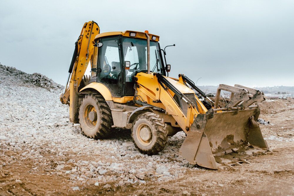 A Yellow Loader is Moving Rocks On A Worksite — BOEX Tyres And Performance in Bowral, NSW