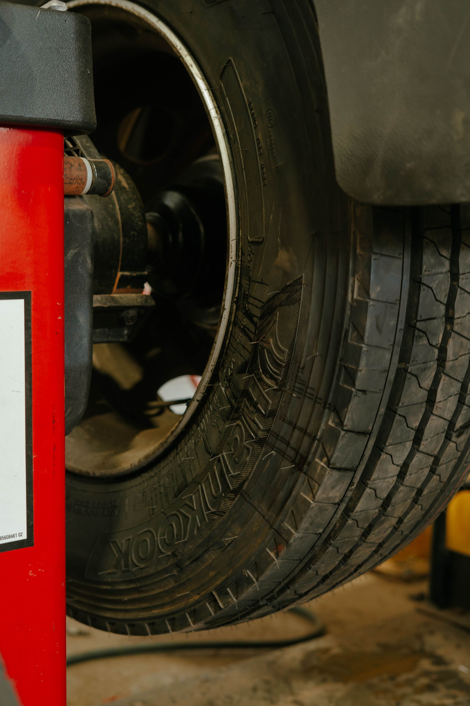 a mechanic works on the wheels of a truck - BOEX Tyres and Performance