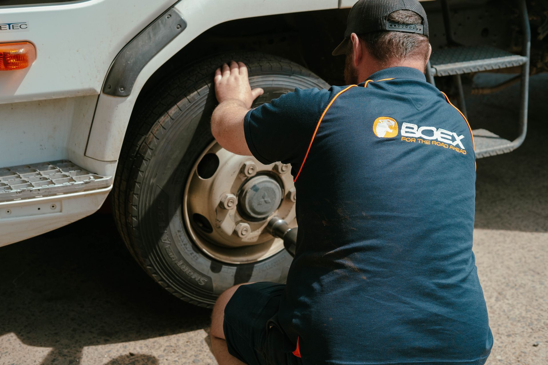 A Man Is Working On A Truck In A Garage — BOEX Tyres And Performance in Bowral, NSW