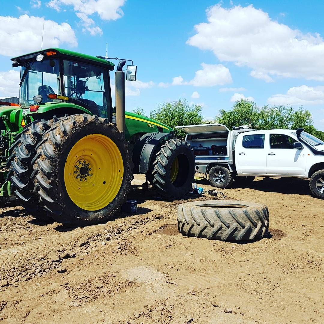 Green Tractor and White Pickup Truck on Muddy Dirt Road — BOEX Tyres And Performance in Bowral, NSW