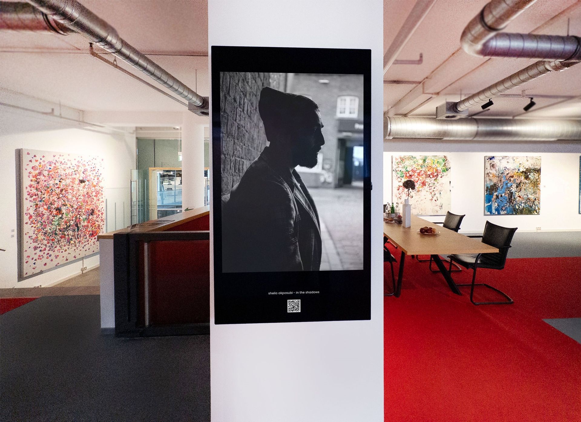 Art gallery with colorful abstract paintings, red carpet, and a central black-and-white portrait panel