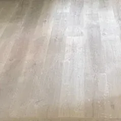 Light wood laminate flooring with pale beige and gray tones, viewed close up.