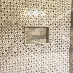 Beige patterned tiled wall with a small rectangular recessed niche