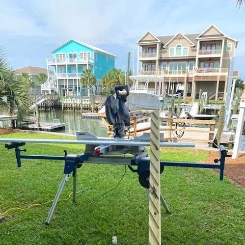 Person standing on a large drone beside a canal with colorful waterfront houses in the background