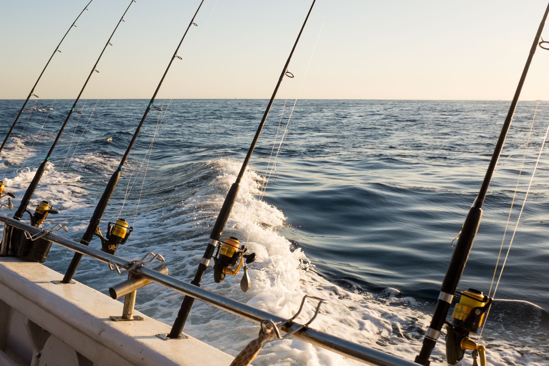 A boat filled with fishing rods is floating on top of a body of water.