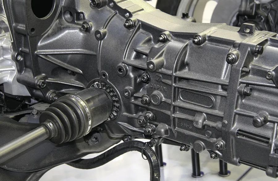 Car transmission with an attached axle; metallic gray.