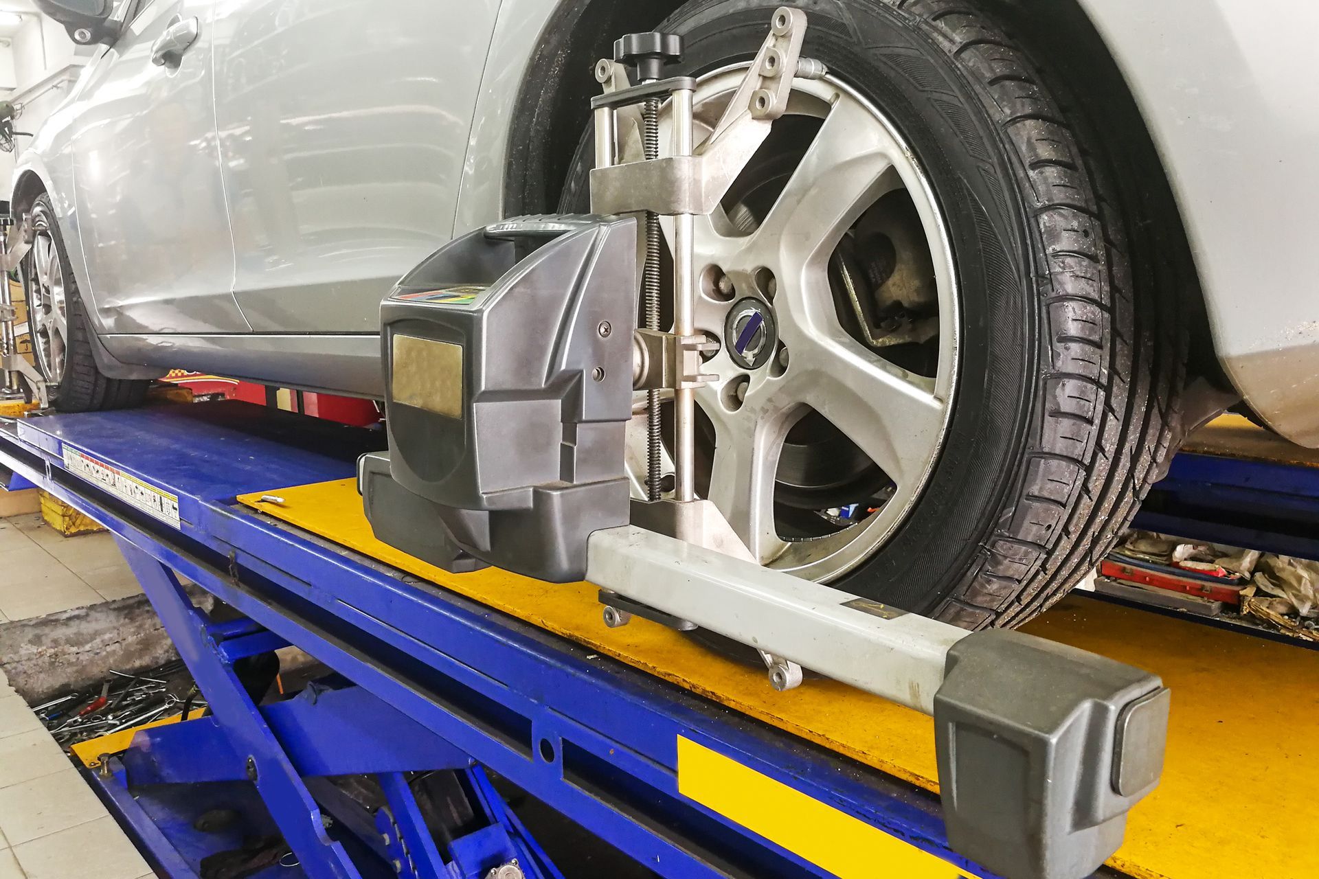 A car is being aligned on a lift in a garage.