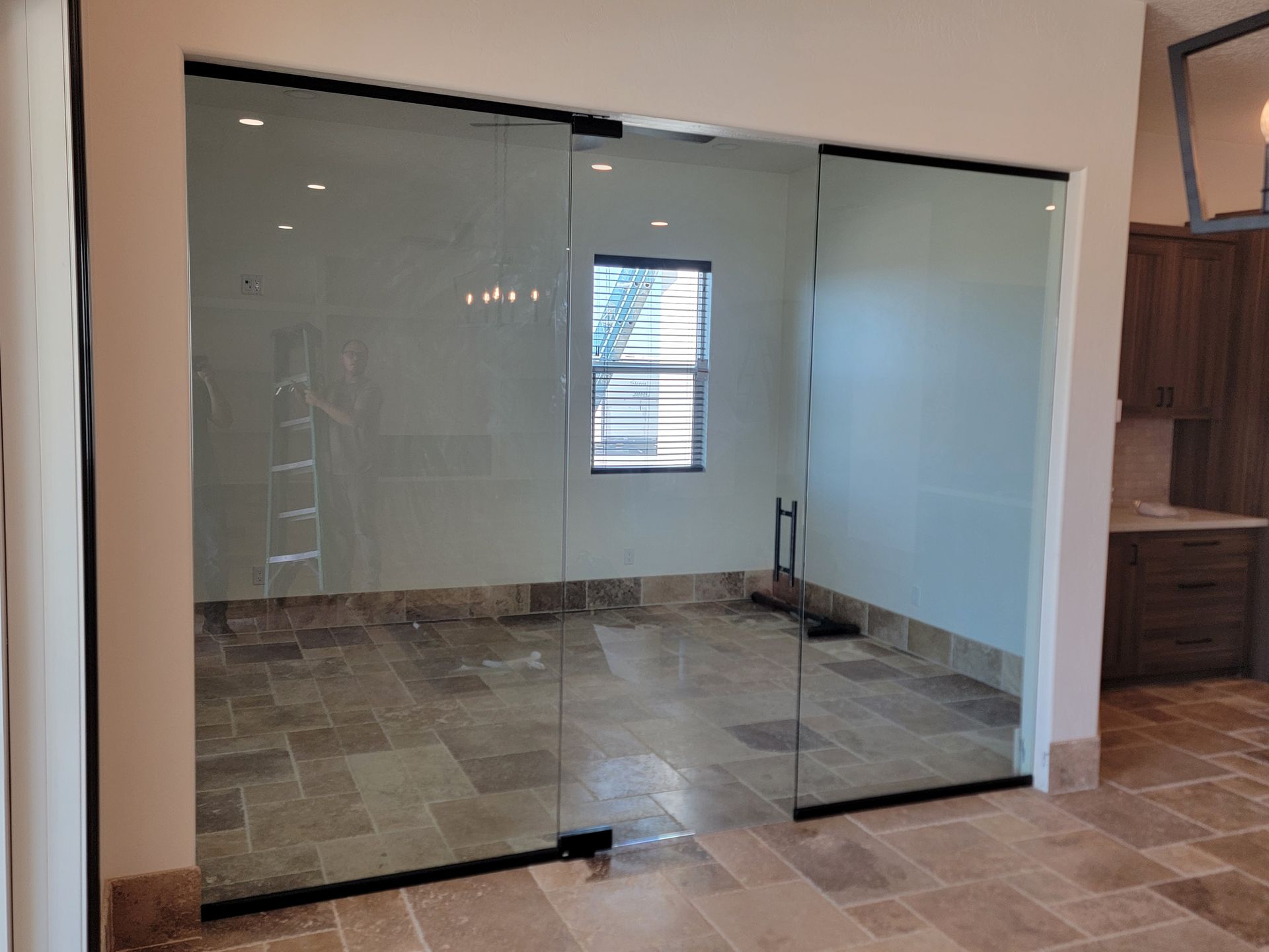 Frameless glass partition wall with black hardware by High Desert Window and Glass