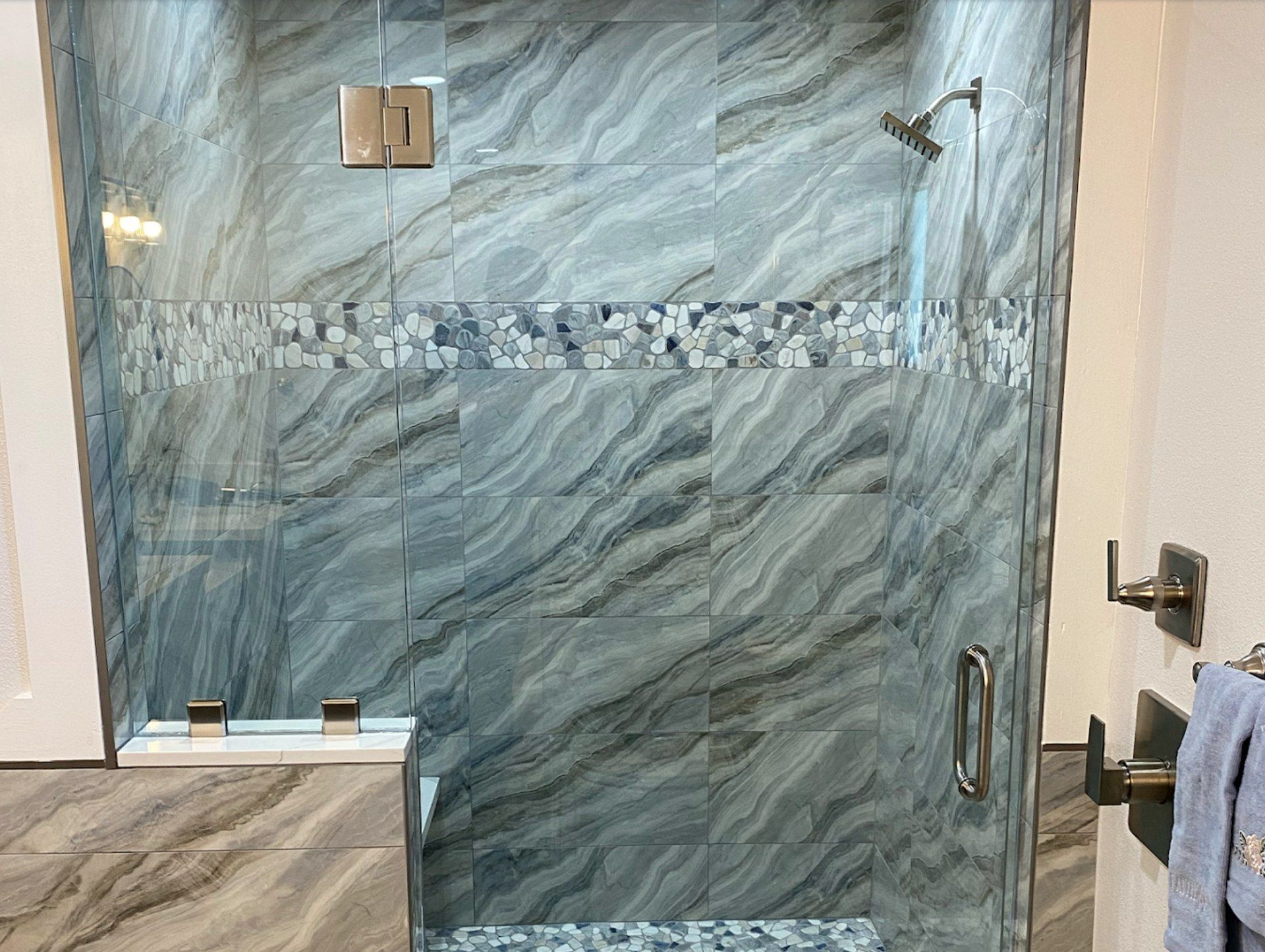 Frameless shower glass panel with blue marble tile by High Desert Window and Glass