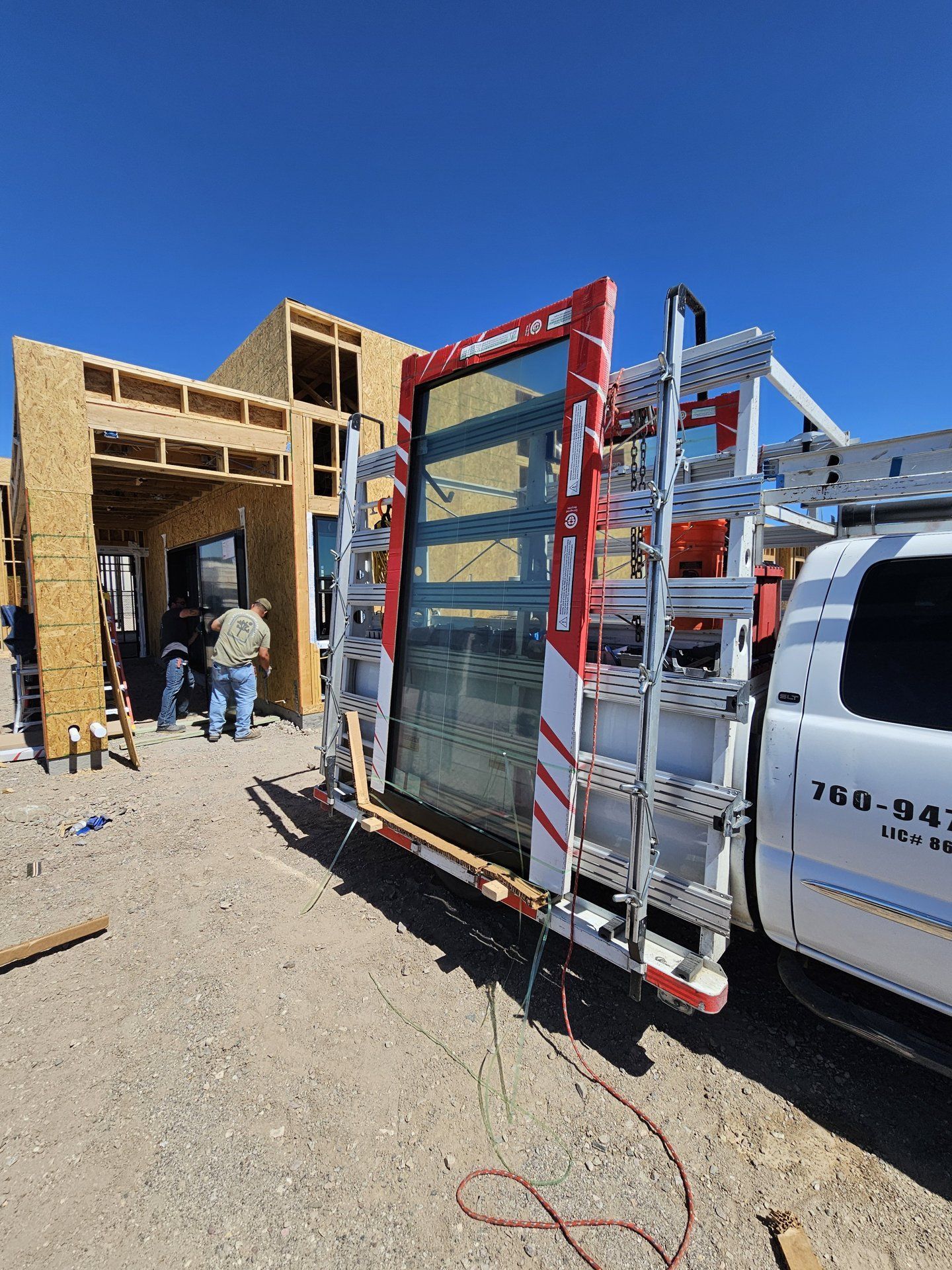 High Desert Window and Glass truck delivering Milgard sliding glass door panels to a job site