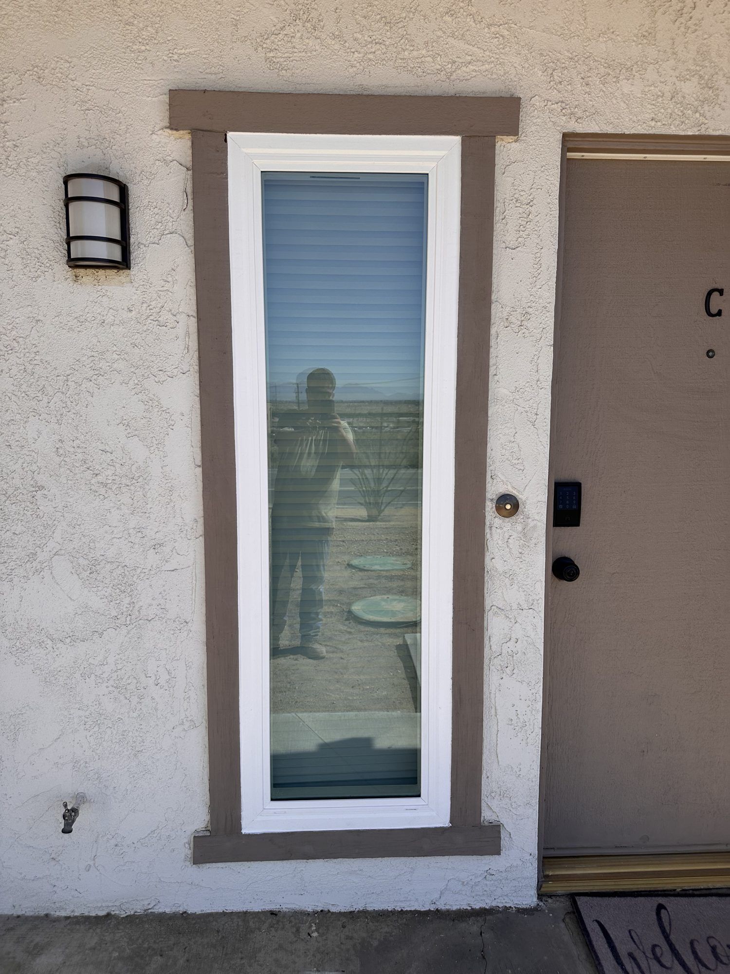 White vinyl retrofit narrow window beside entry door by High Desert Window and Glass