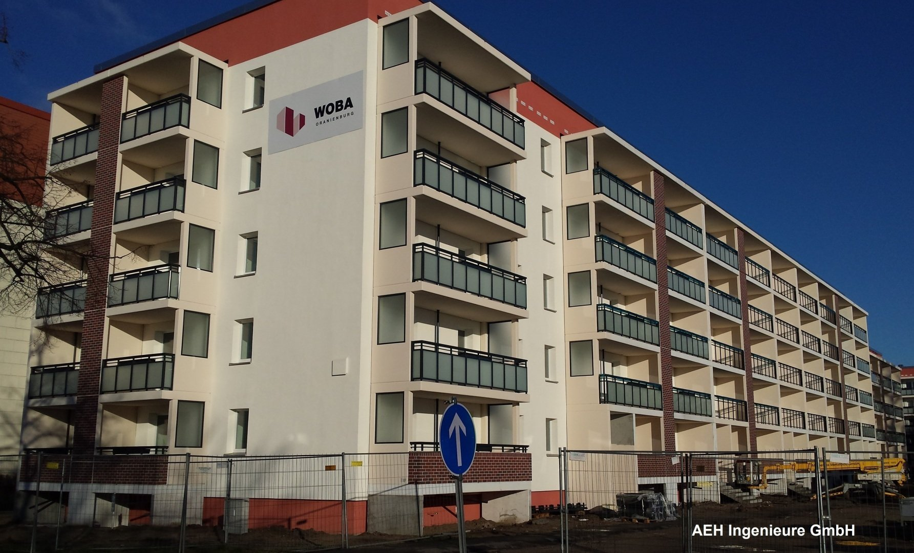 Ein großes weißes Wohnhaus mit einem roten Dach