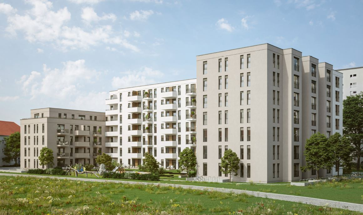 Ein großes Gebäude mit vielen Fenstern ist von Gras und Bäumen umgeben.
