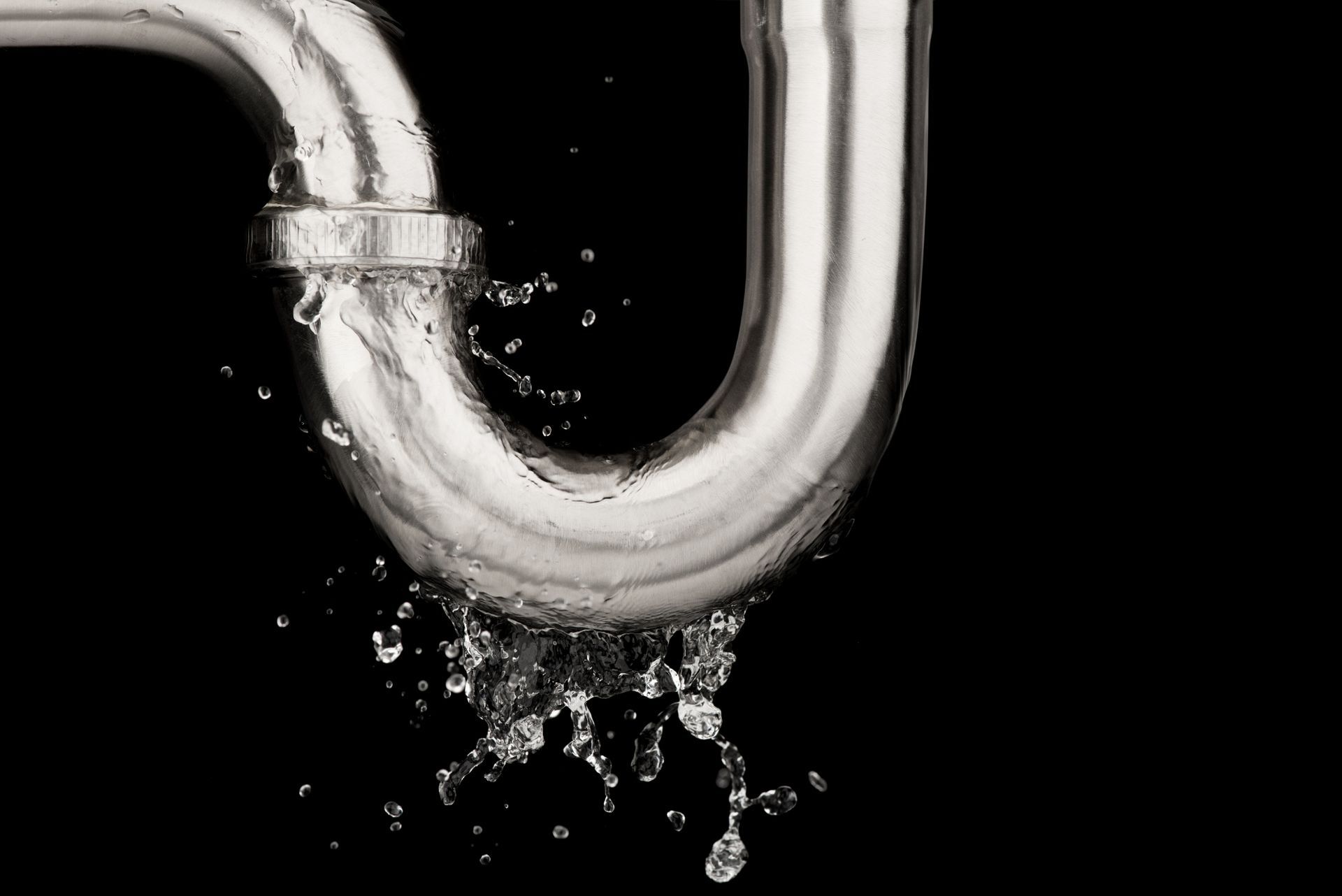 Water is coming out of a stainless steel pipe on a black background.