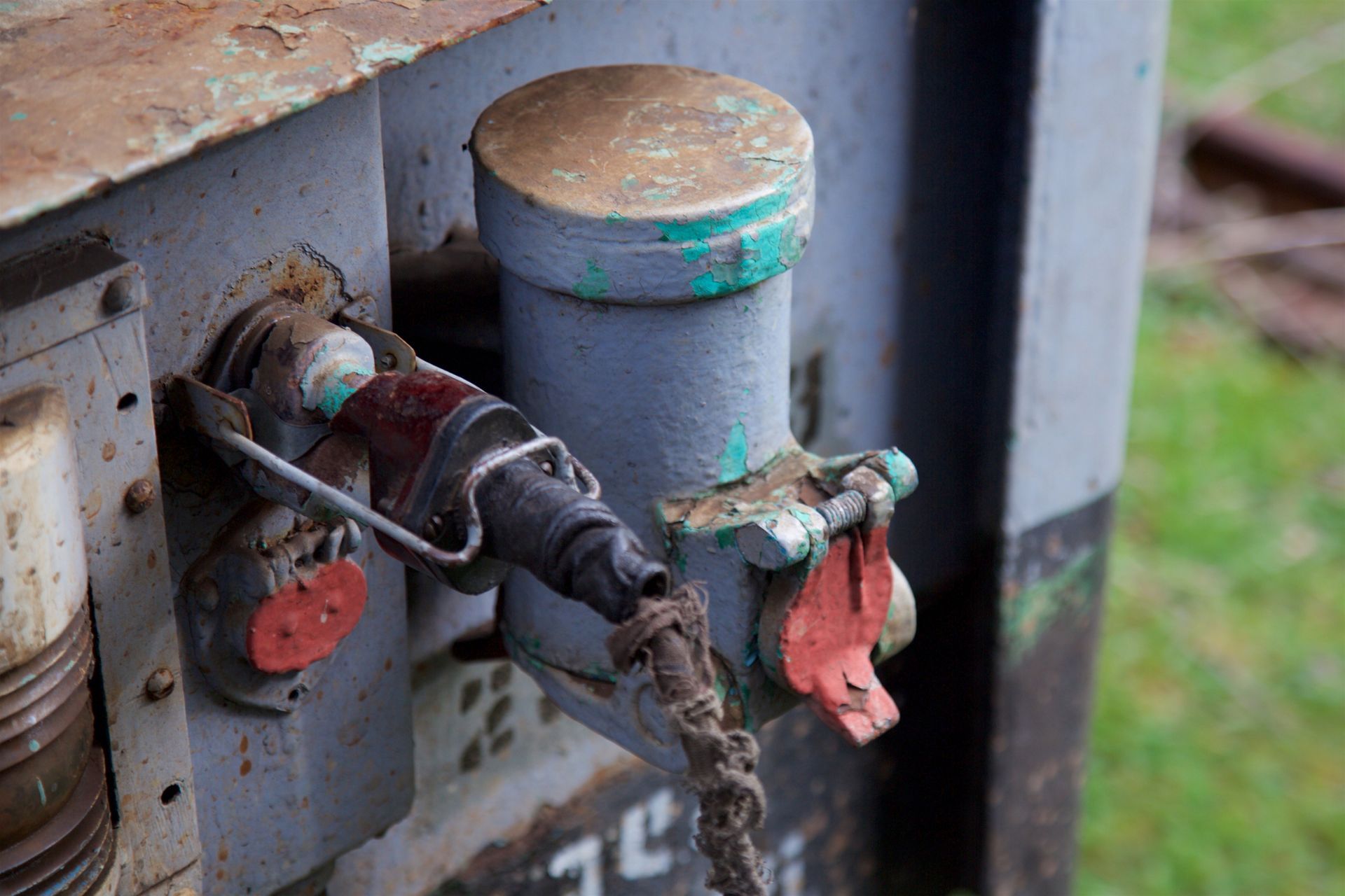 A close up of a valve on a rusty metal object.