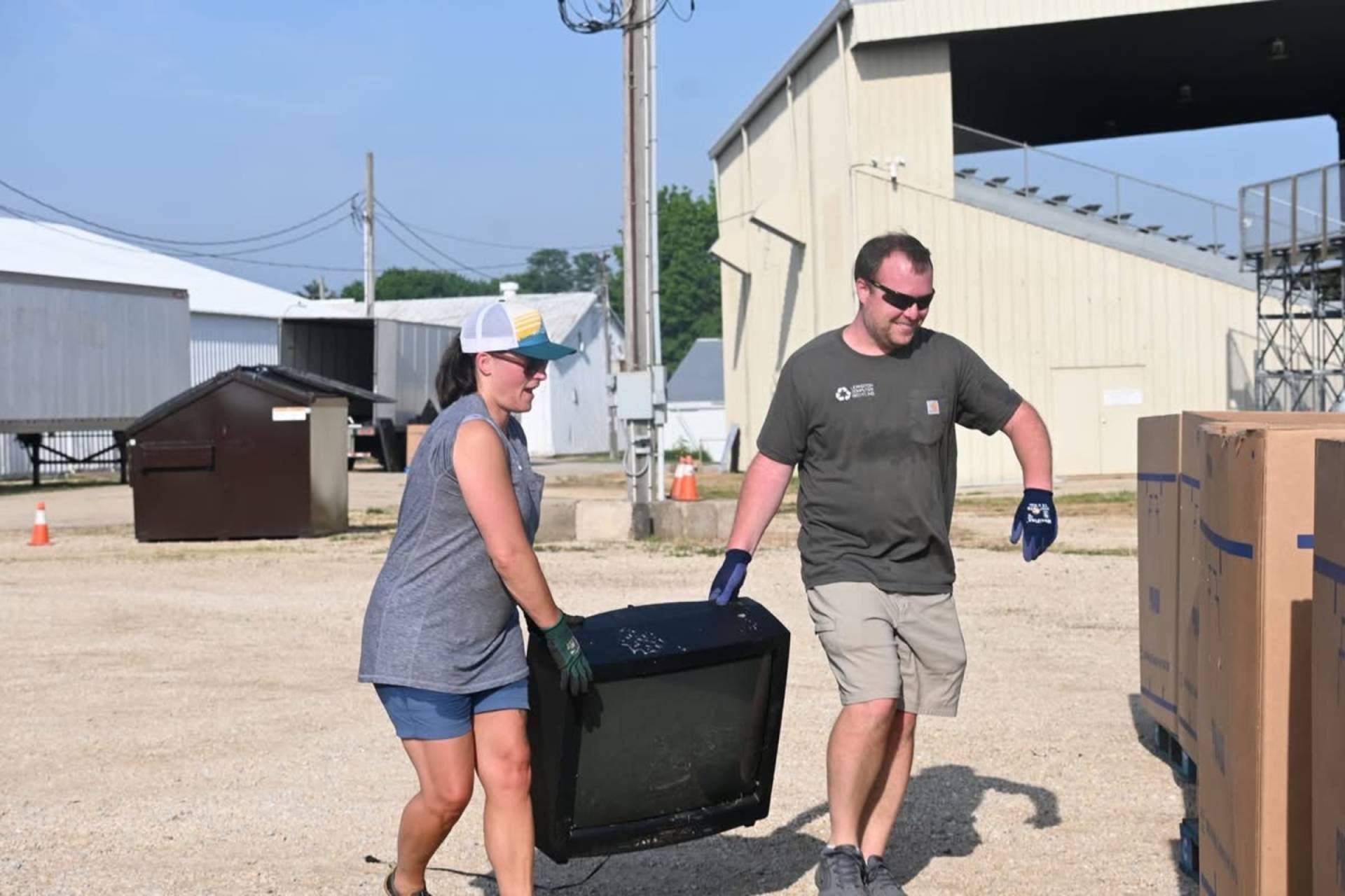 Volunteer and Lexington Computer Recycling team member hands holding console TV to be recycled.