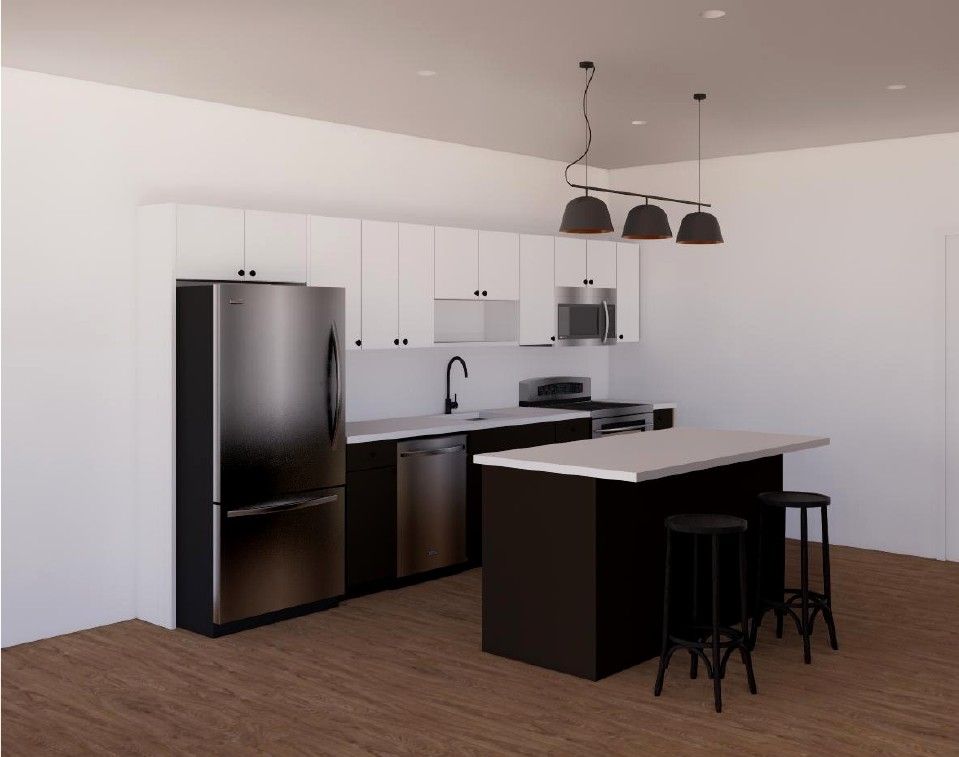Modern kitchen with black appliances, white cabinets, dark island, and two pendant lights.