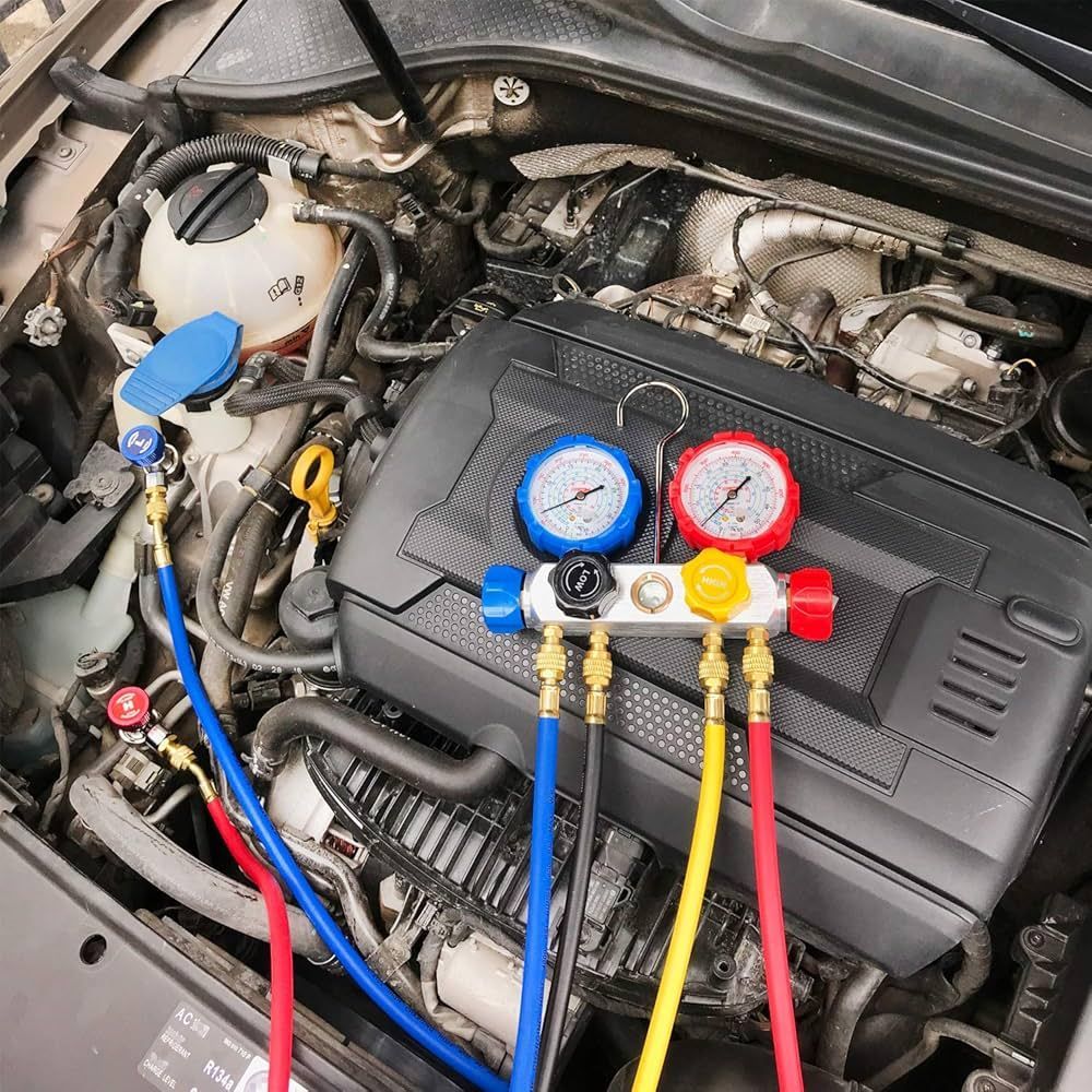 Automotive A/C manifold gauges connected to vehicle air conditioning system during climate control