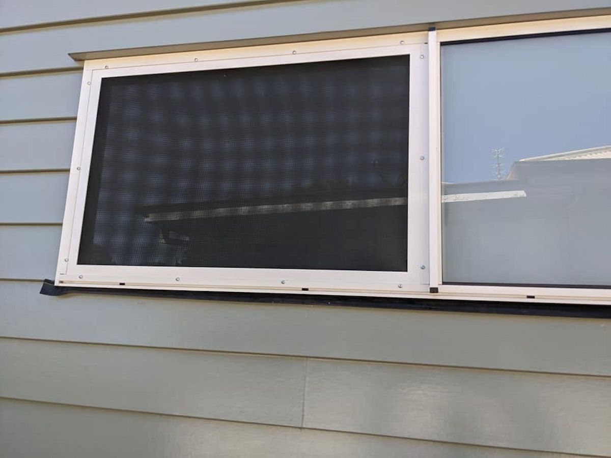 White-framed Screened Window on a Light Gray House Exterior — Toowoomba Locksmiths in Toowoomba City, QLD