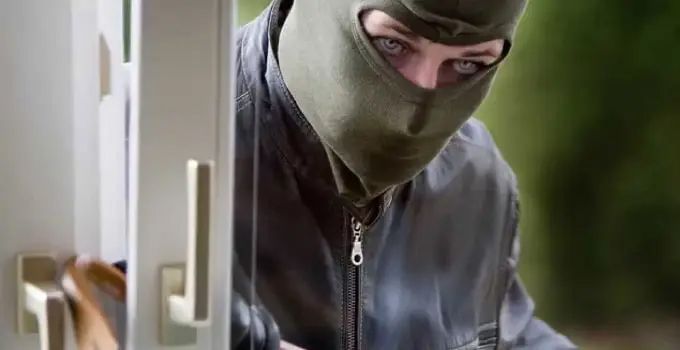 Man in A Mask Is Breaking Into a Door — Toowoomba Locksmiths in Toowoomba City, QLD
