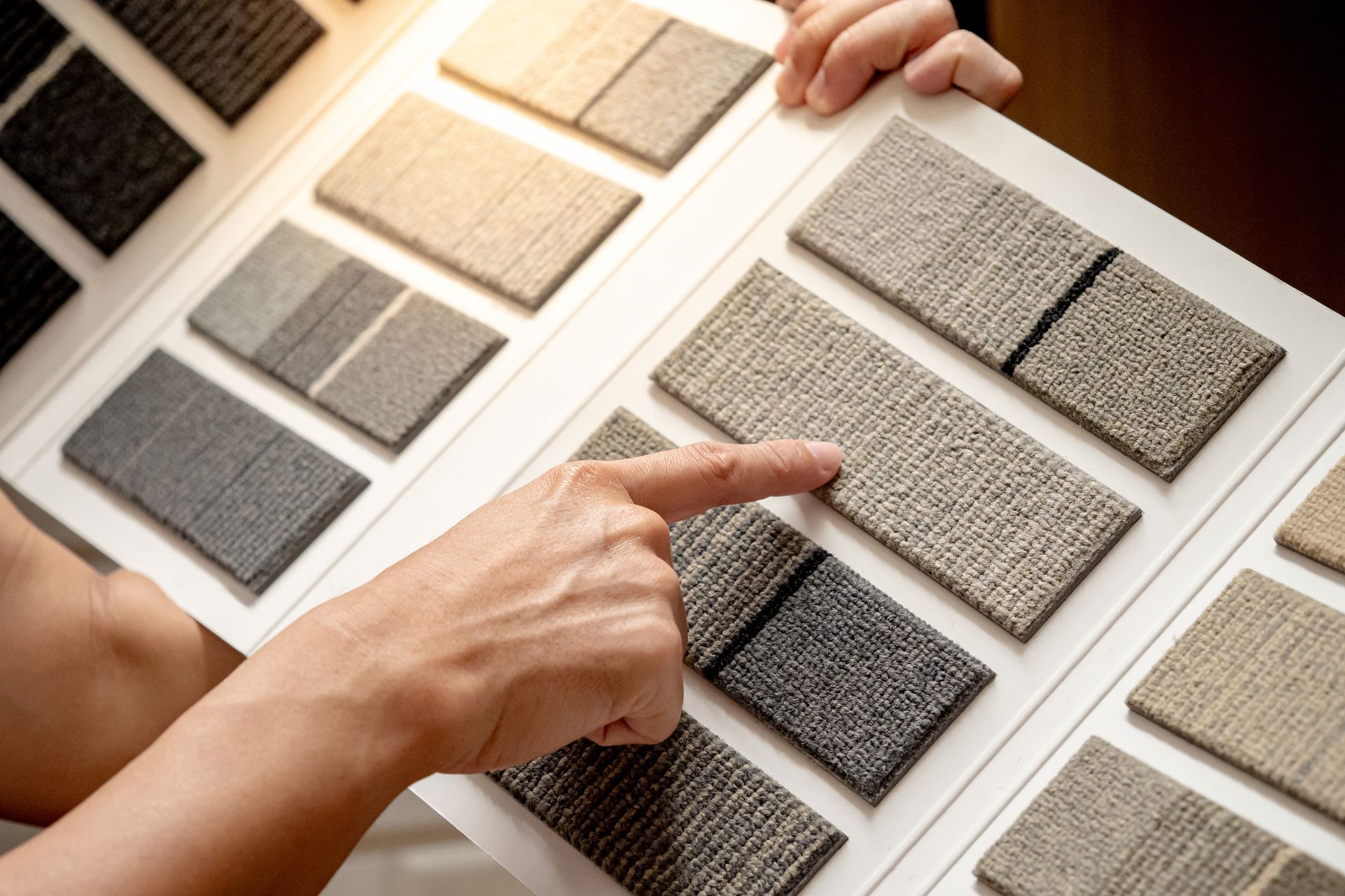 A person is looking at carpet tile samples.