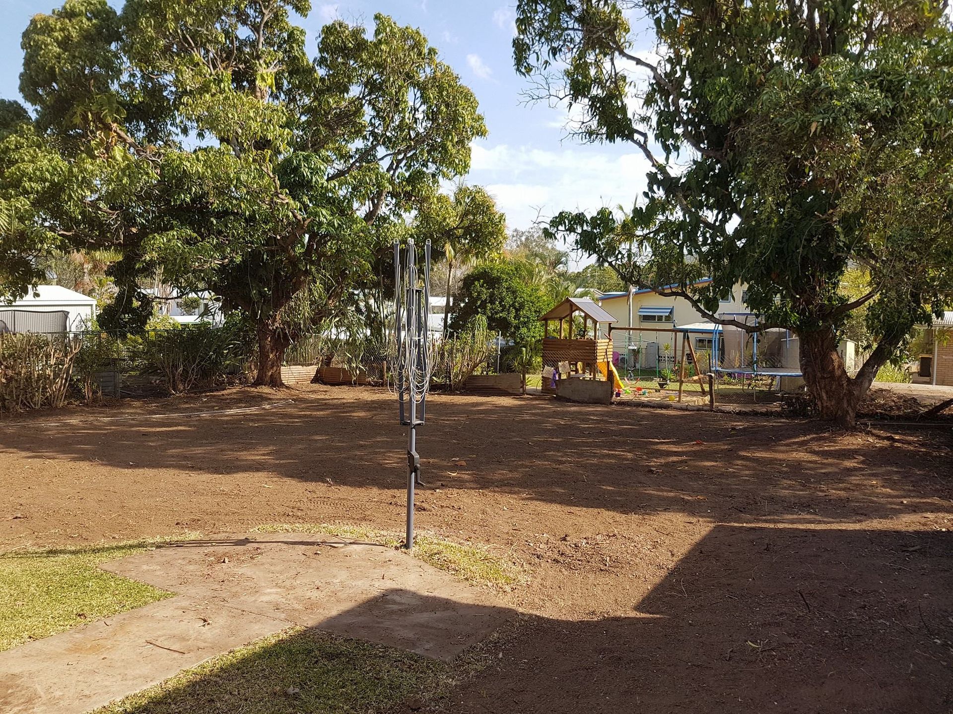 A White-sided Building With a Corrugated Metal Roof — Barlows Tree Services in Rockhampton, QLD