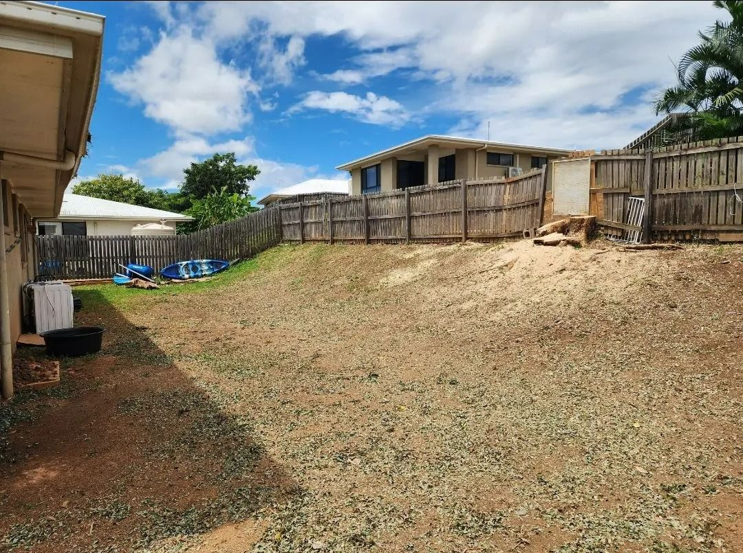 Backyard With a Sloped Dirt Yard, Wooden Fence, and a House — Barlows Tree Services in Rockhampton, QLD