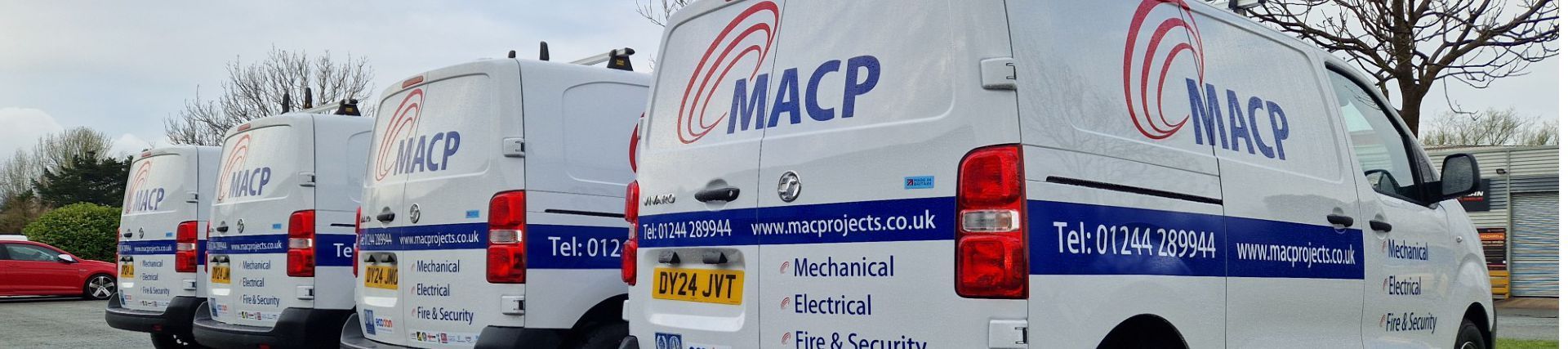 White vans with “MACP” logos parked in a row.