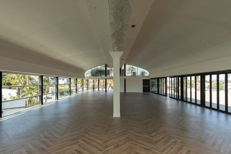 A large empty room with a lot of windows and a wooden floor.
