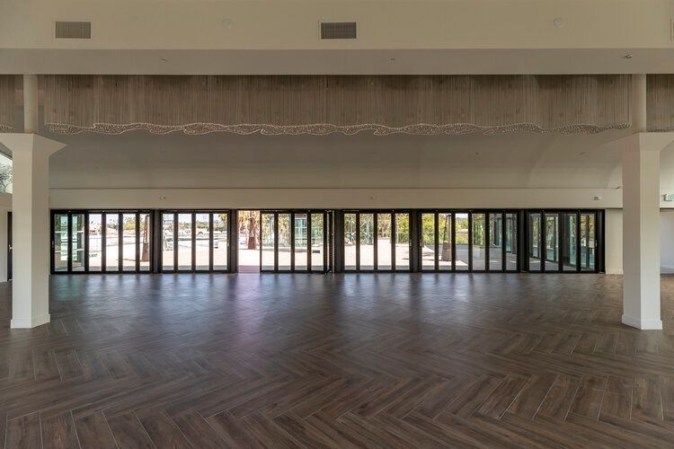 A large empty room with lots of windows and wooden floors.
