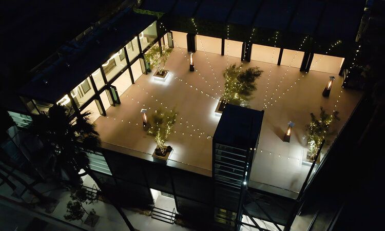 An aerial view of a building at night with trees and lights