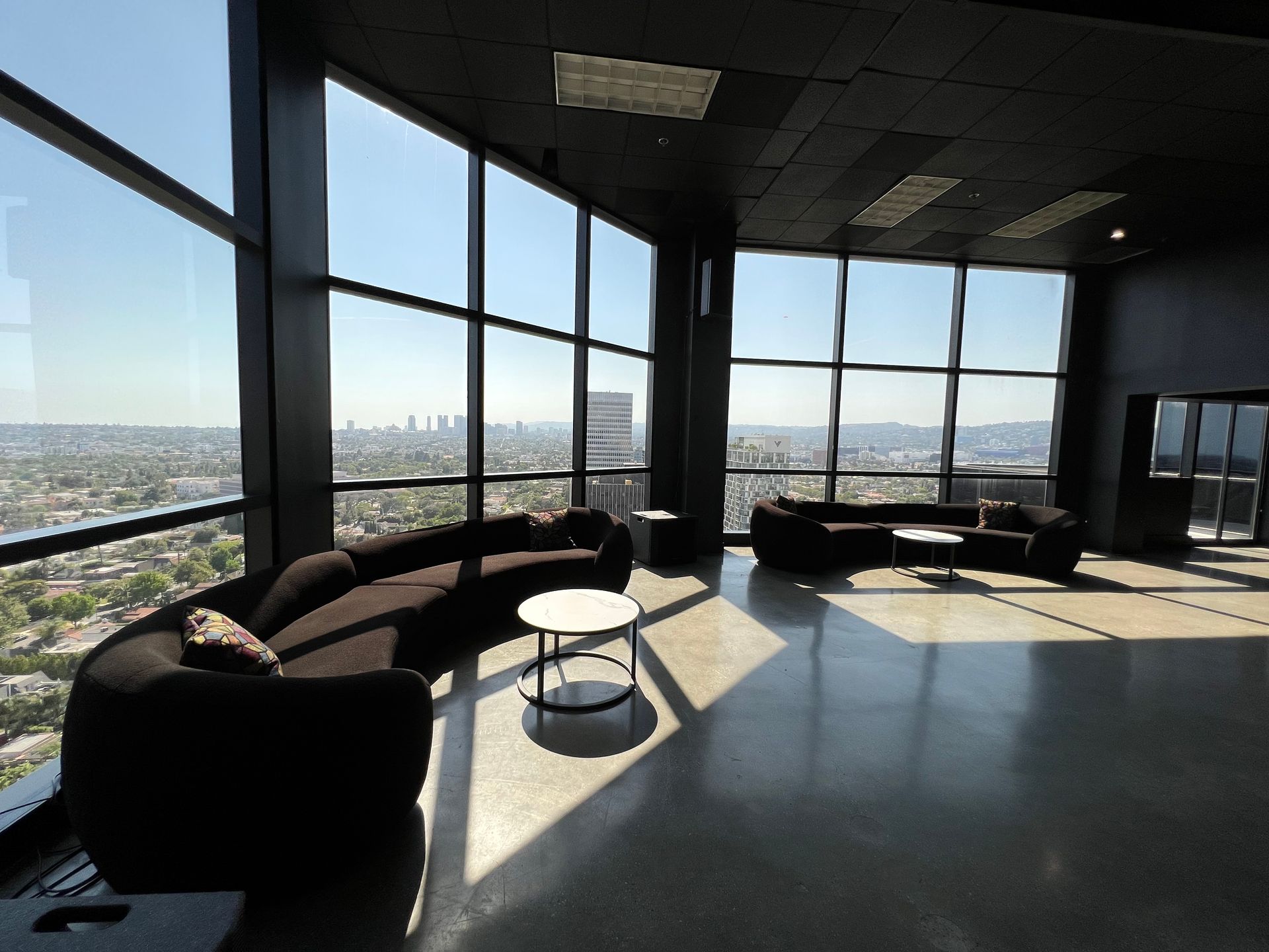 A living room with lots of windows and a view of the city