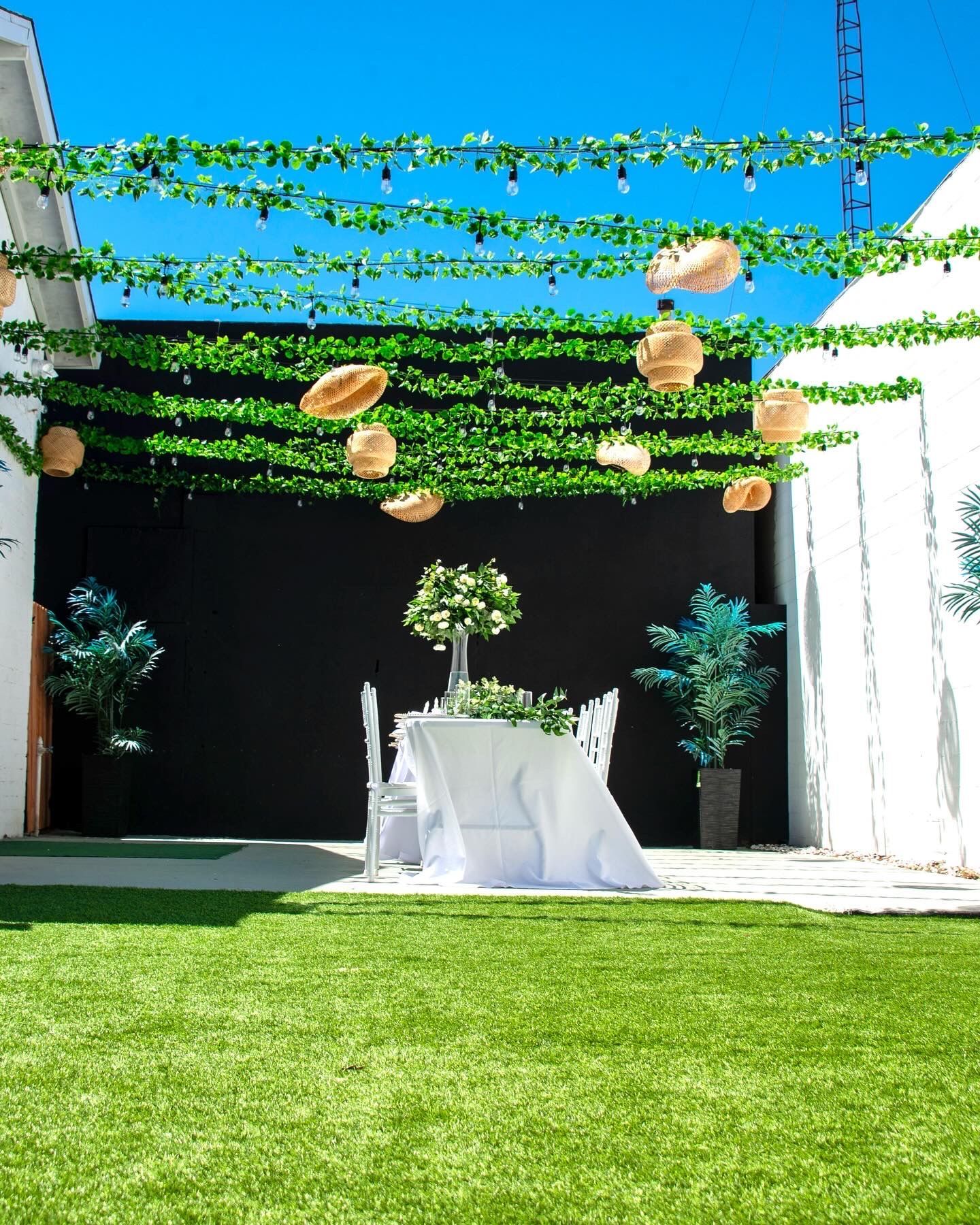 A table and chairs are sitting in the grass under a canopy.