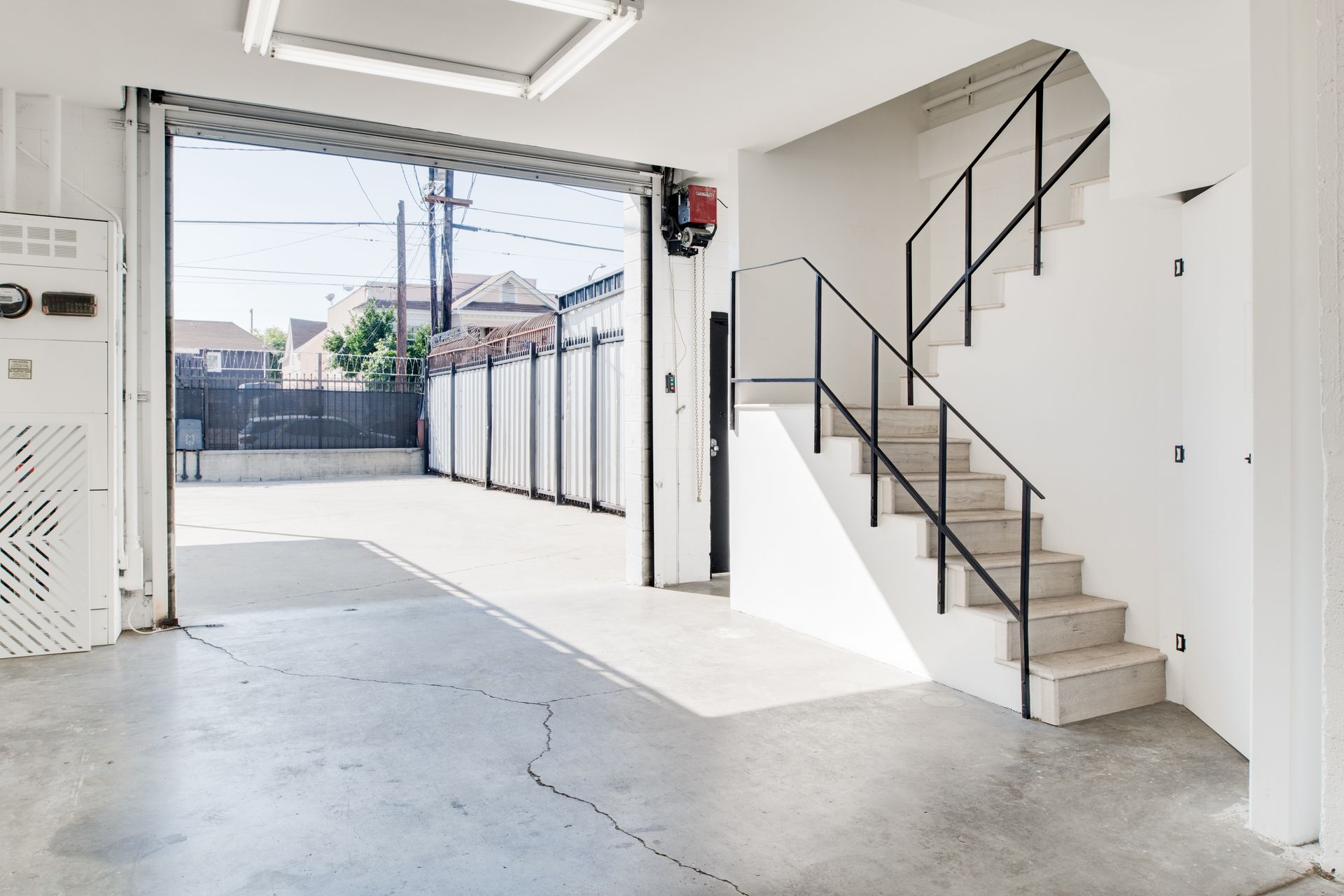 A garage with stairs leading up to the second floor