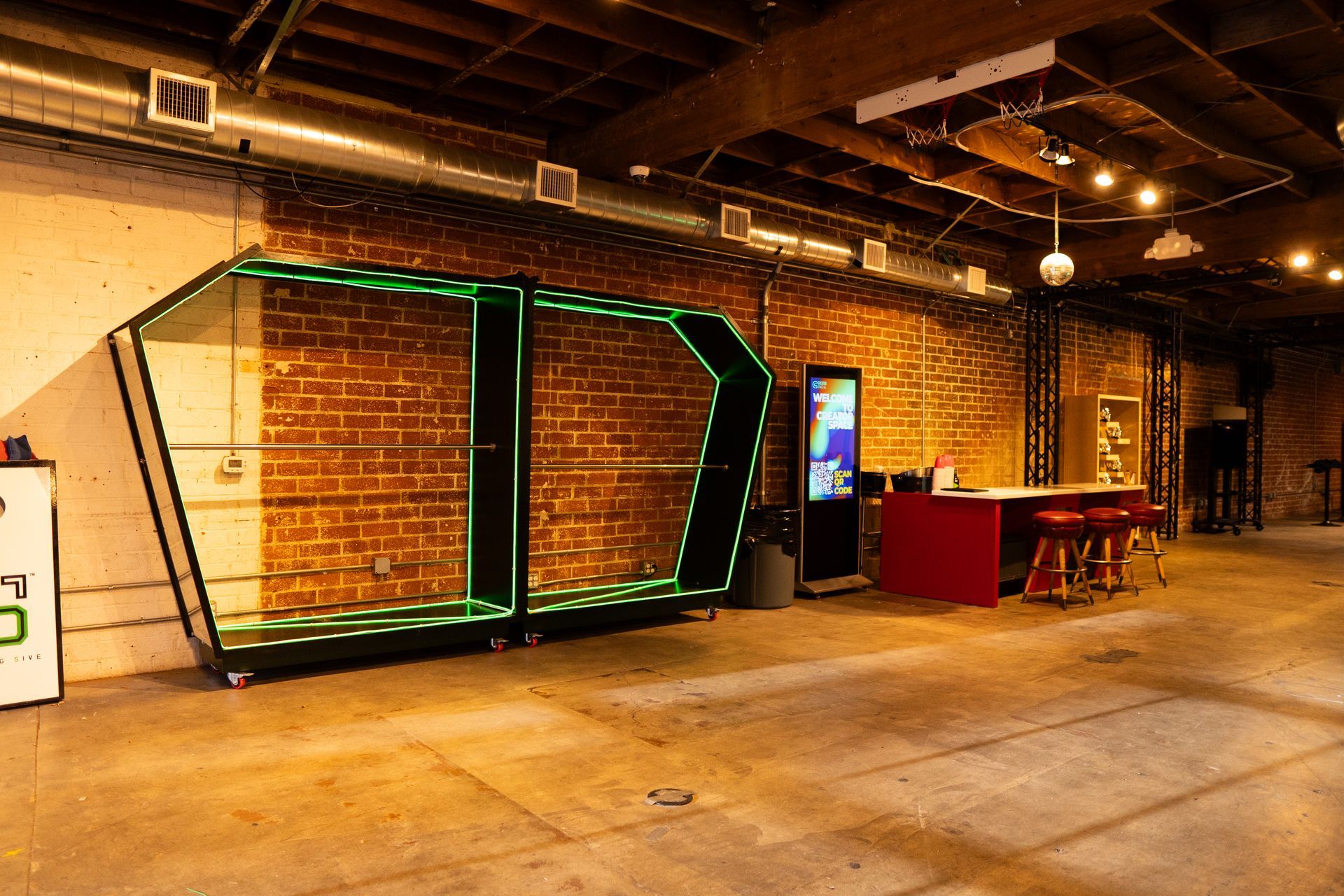 A modern, industrial-style room featuring two large, neon-lit green shelving units against an exposed brick wall.