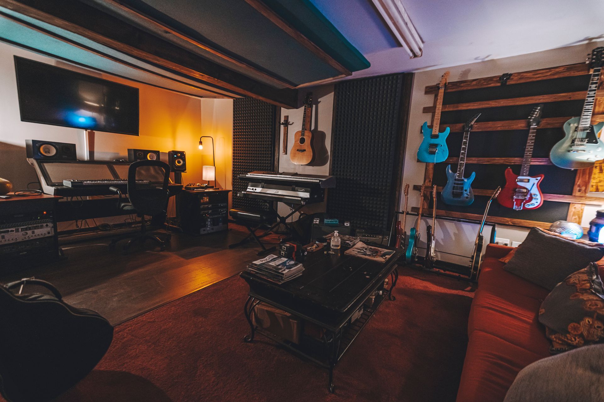 There are many guitars hanging on the wall in this room.