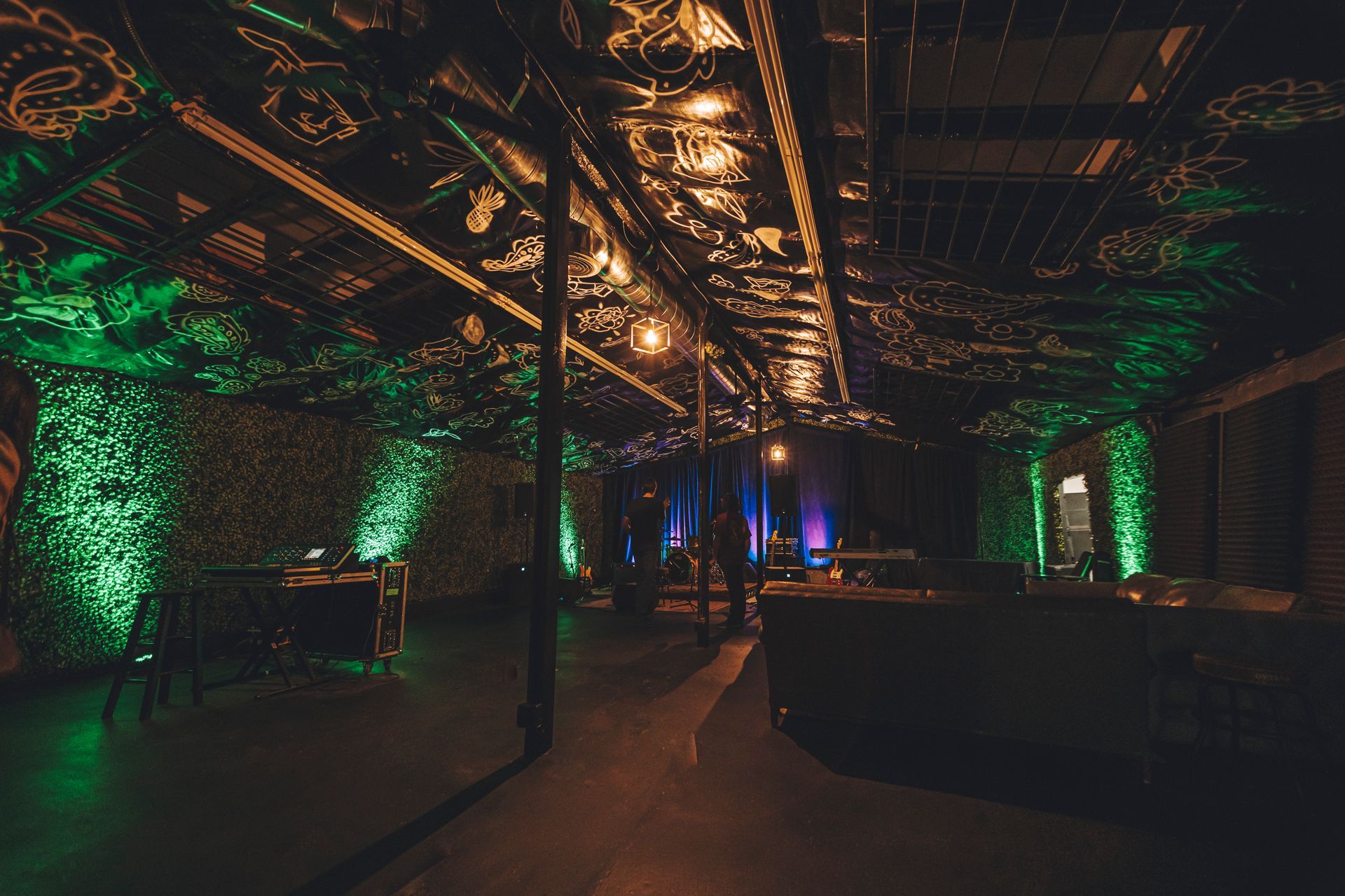 A dark room with green lights on the walls and ceiling.