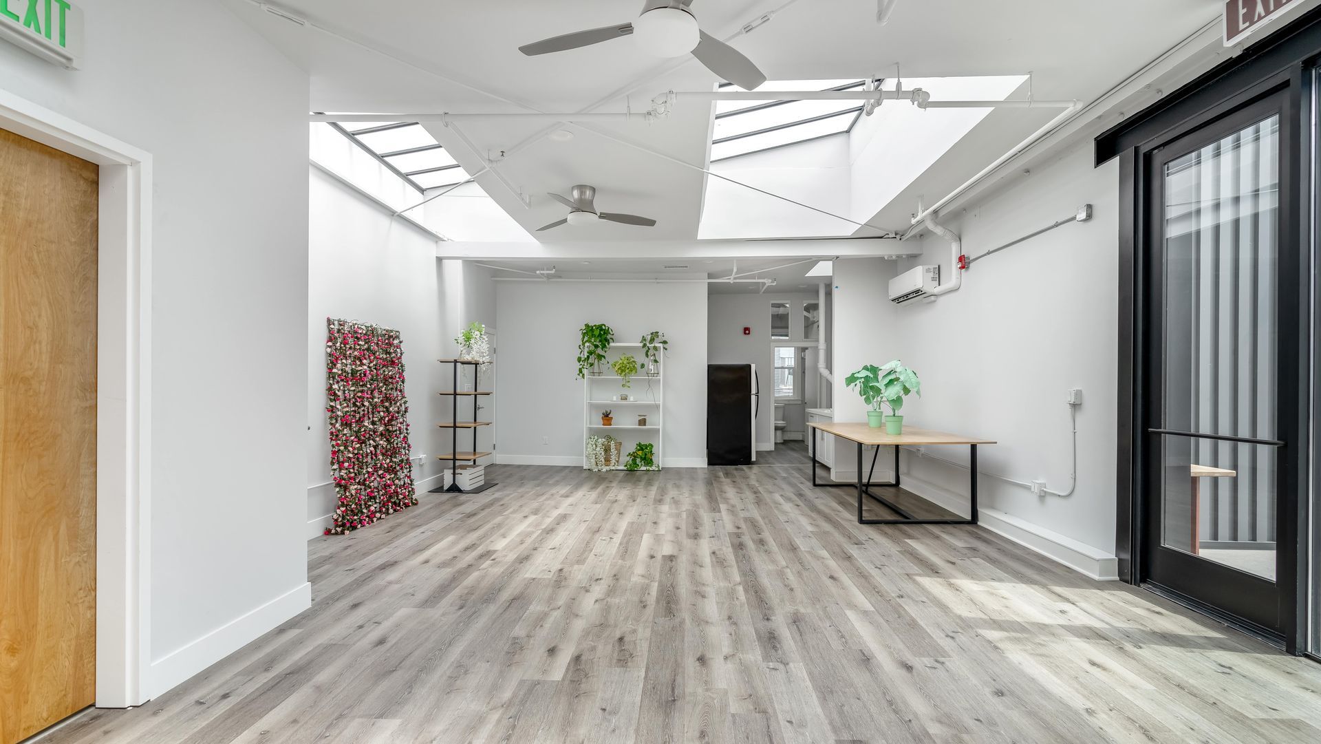 A large empty room with a wooden floor and white walls.