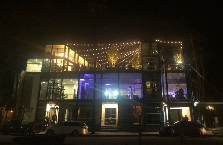 A large building with a lot of windows is lit up at night.