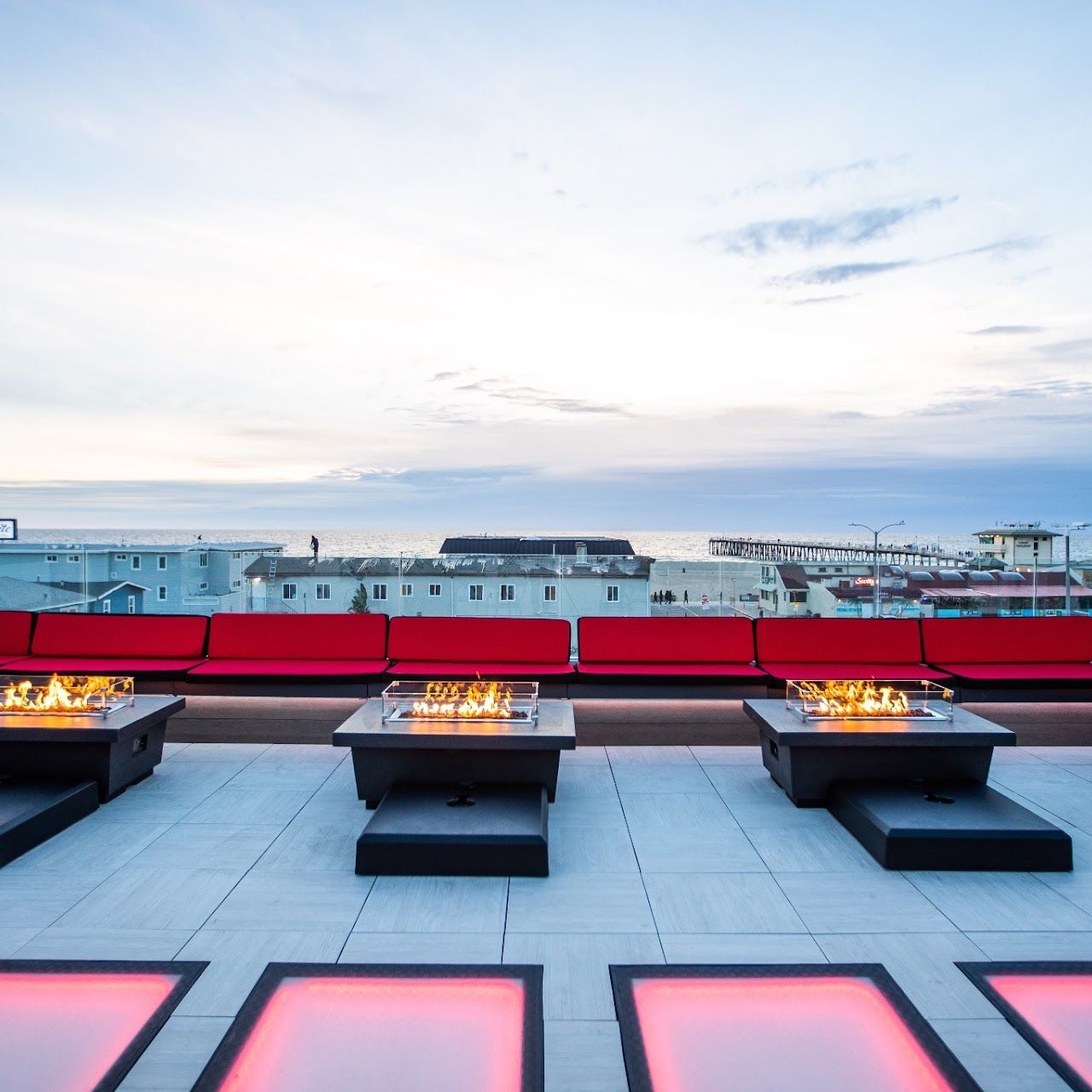 A row of tables with a fire pit in the middle of them