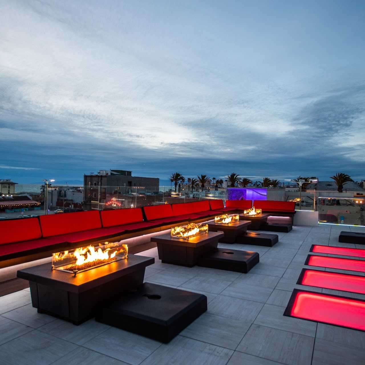 A row of tables with a fire pit in the middle