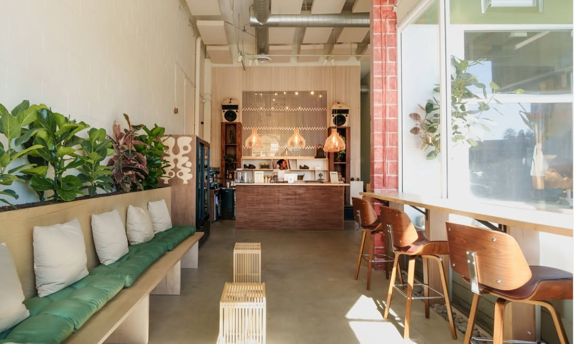 A restaurant with a long bench and chairs and a counter.