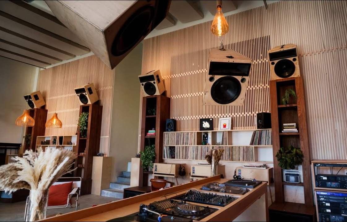 A room with a lot of speakers on the wall and a table with speakers on it.