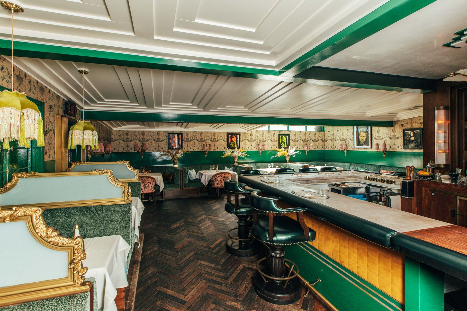 A restaurant with a long bar and tables and chairs.