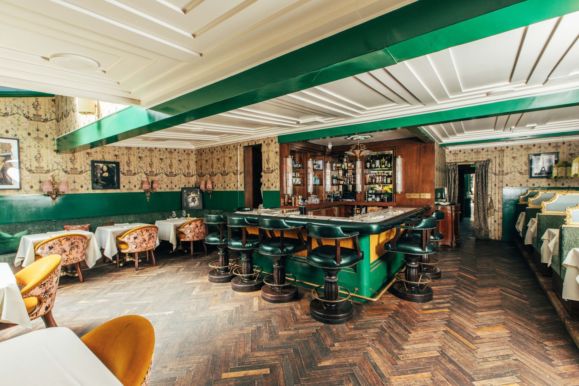 A large room with tables and chairs and a bar in the middle.