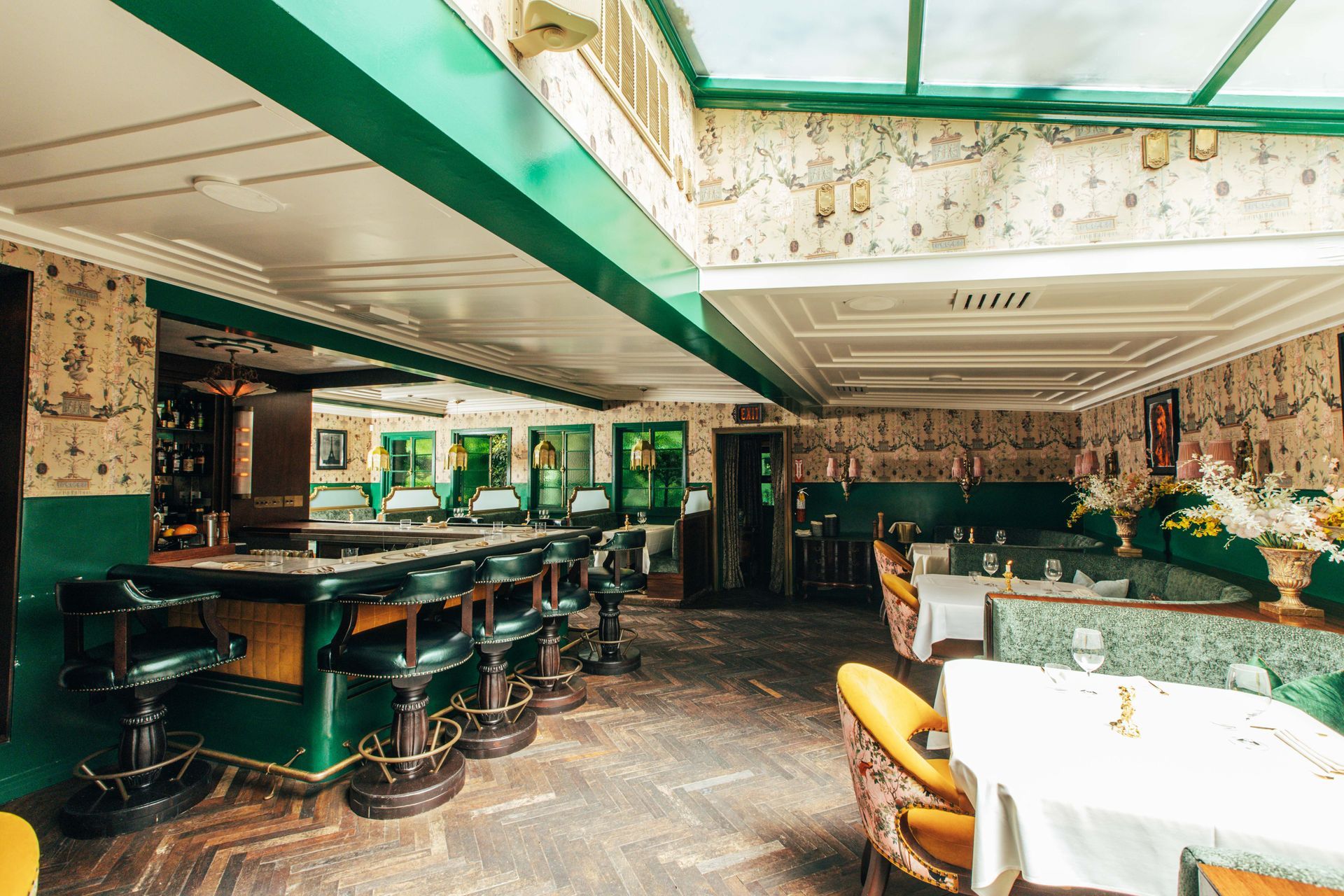 A restaurant with tables and chairs and a bar.